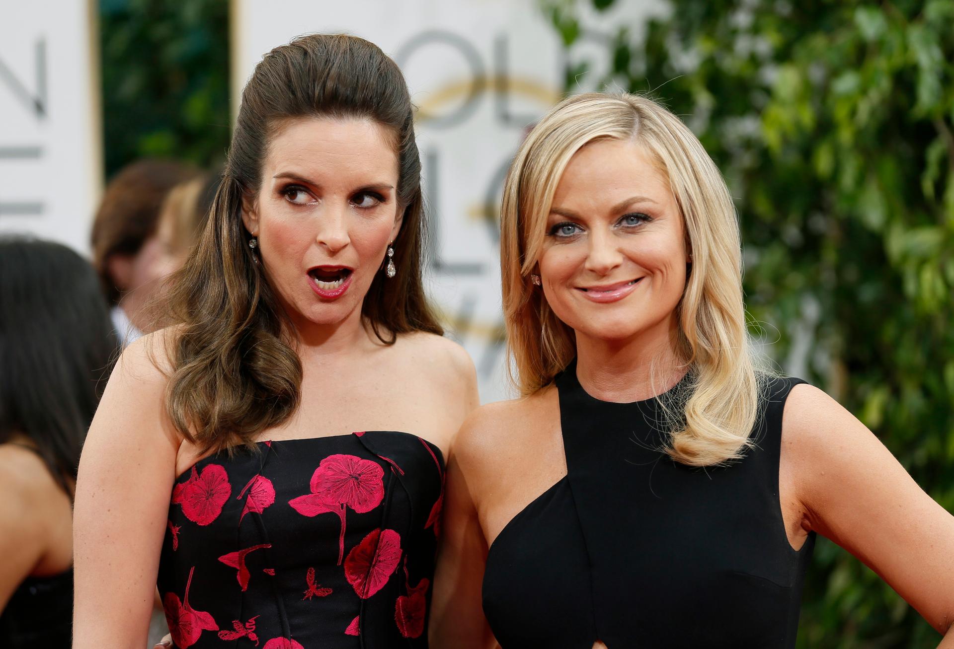 Golden Globes hosts Tina Fey and Amy Poehler pose at the 2014 Golden Globe Awards.
