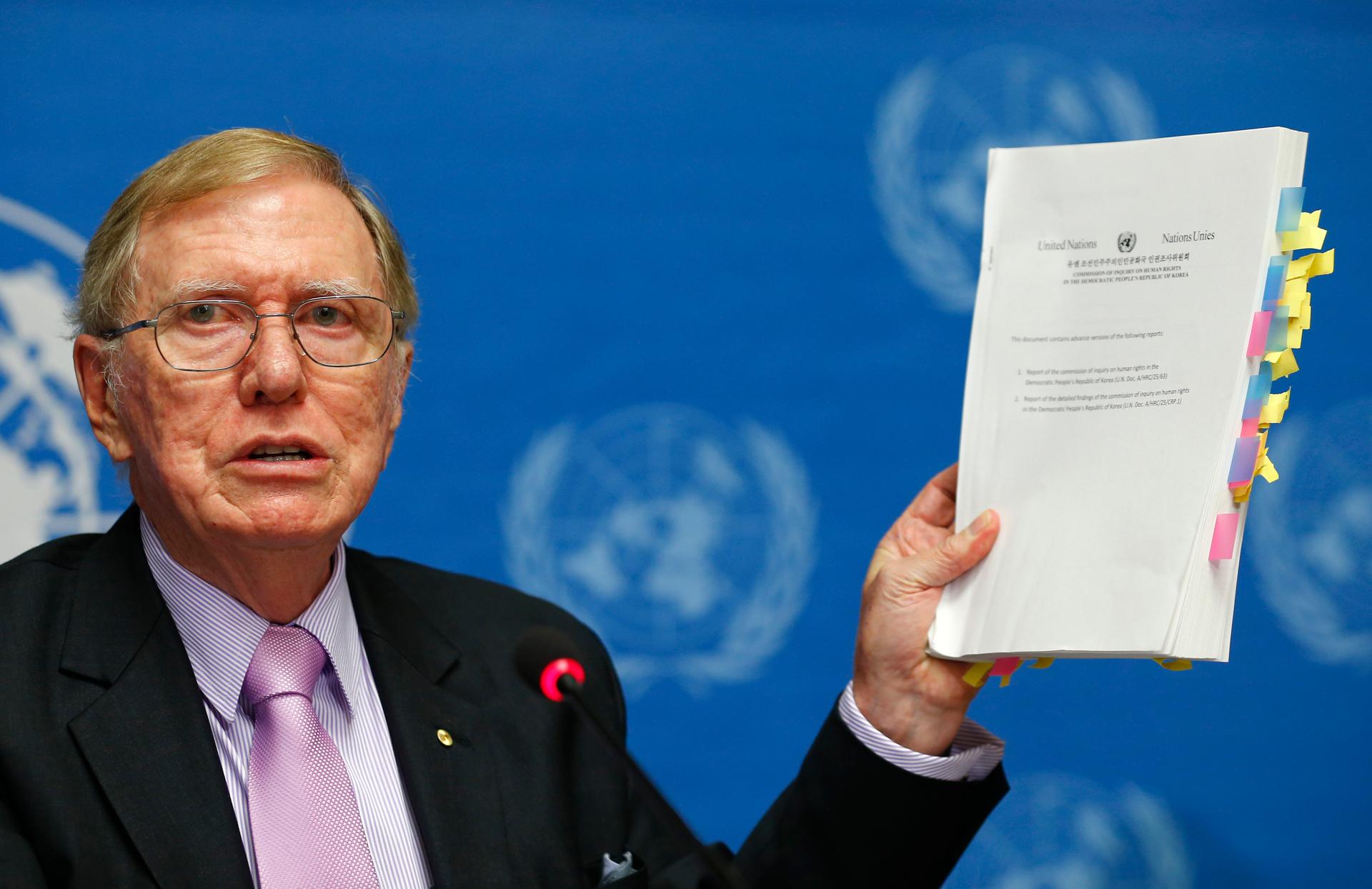 Michael Kirby, who helped lead the Commission of Inquiry on Human Rights in North Korea, holds a copy of his report during a news conference at the United Nations in February 2014.