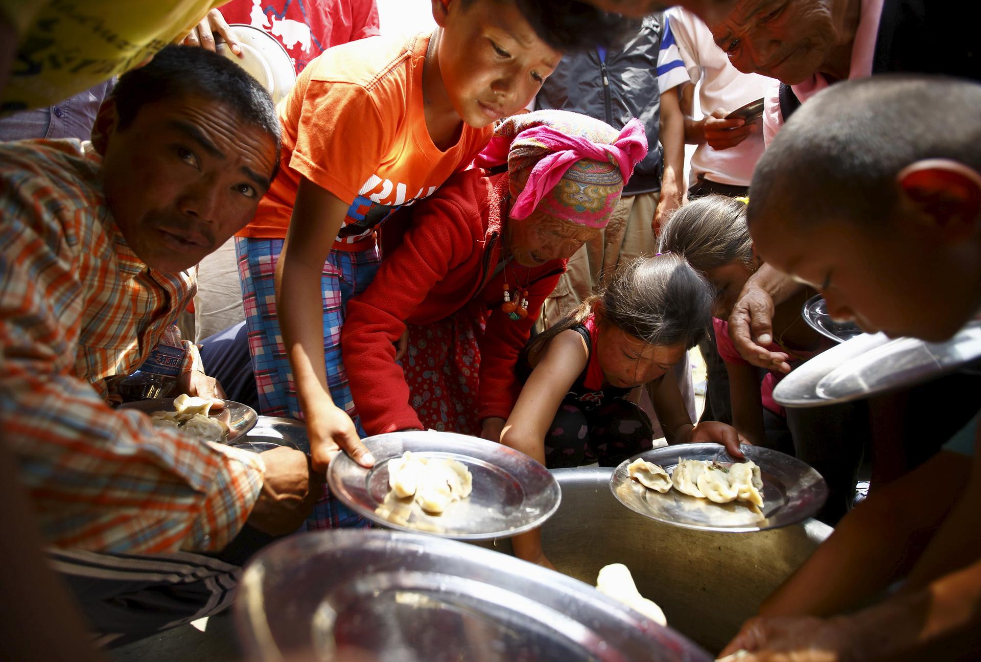 Earthquake victims gather to receive food at a Tibetan monastery, a month after the April 25 earthquake, in Kathmandu, Nepal