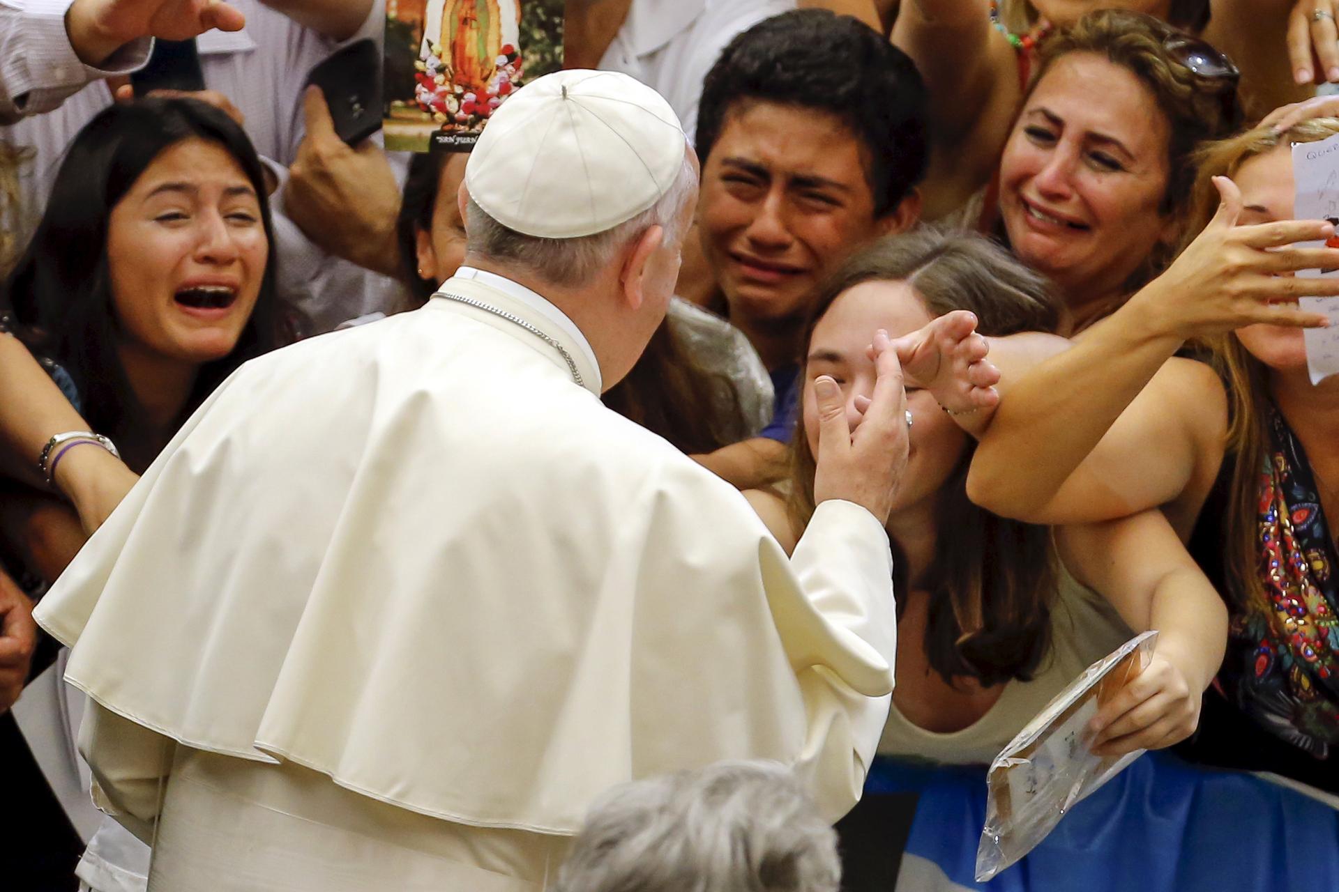 Faithful react as Pope Francis arrives to lead his weekly audience at Vatican City in Rome on August 5, 2015.