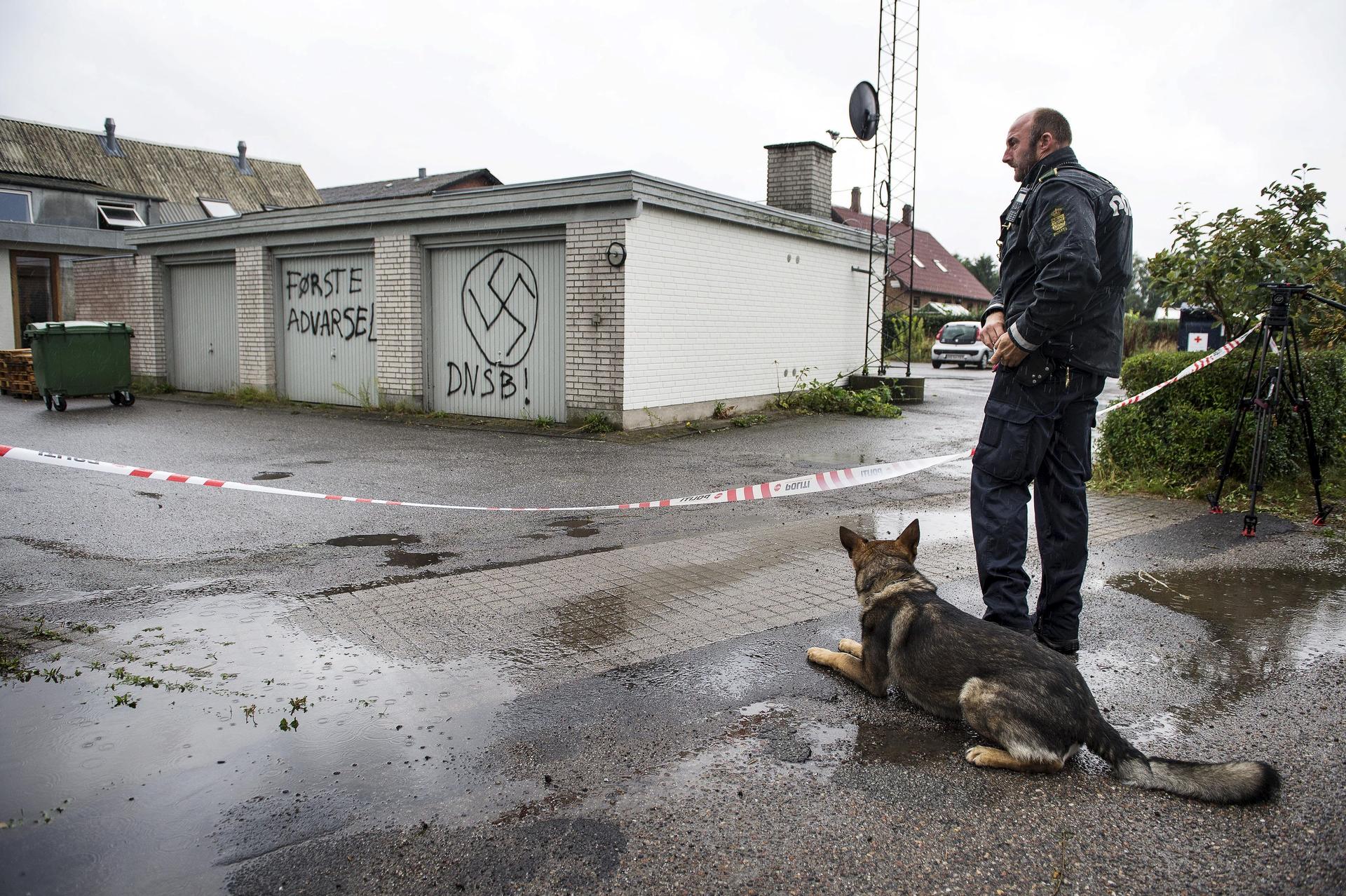 A policeman stands guard in front of the Red Cross asylum center in Lyngbygaard in Trustrup, in the west of Denmark, August 27, 2015.