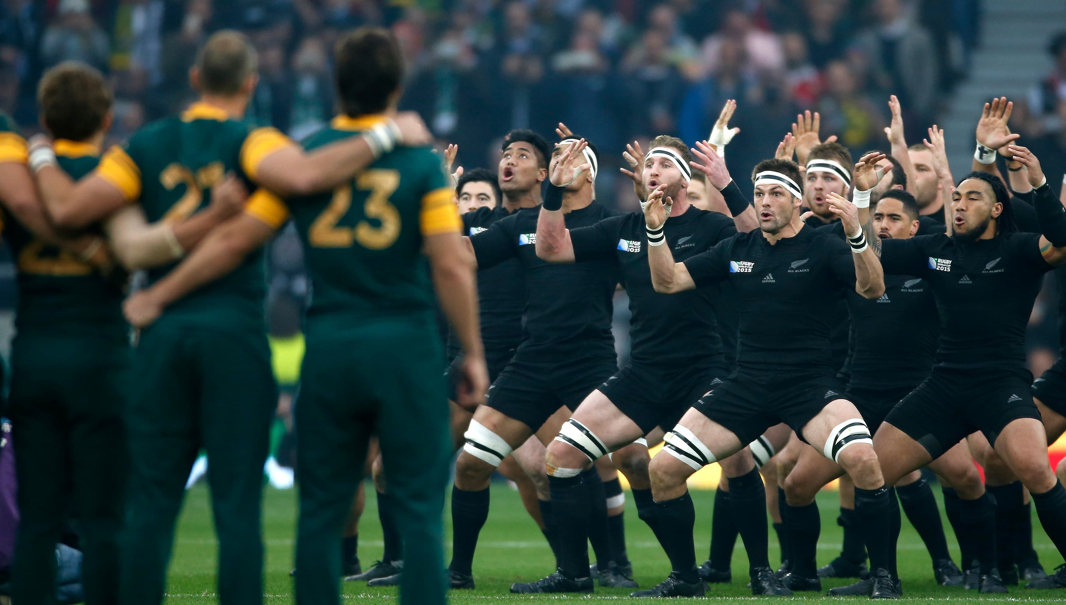 Men in black uniforms facing each other doing dance