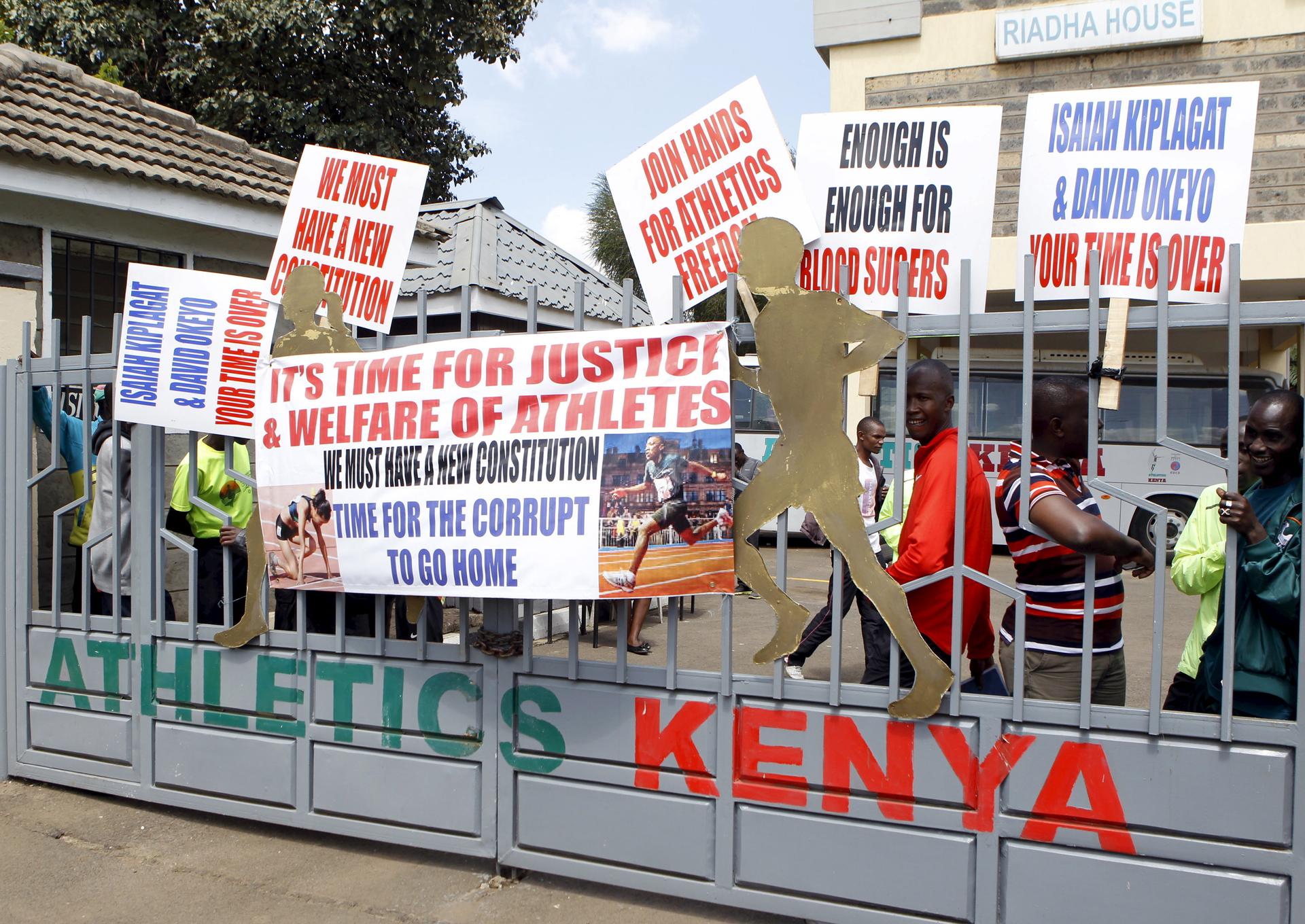 Protesting Kenyan athletes place placards behind closed gates at Riadha House the Athletic Kenya (AK) Headquarters in capital Nairobi November 23, 2015.