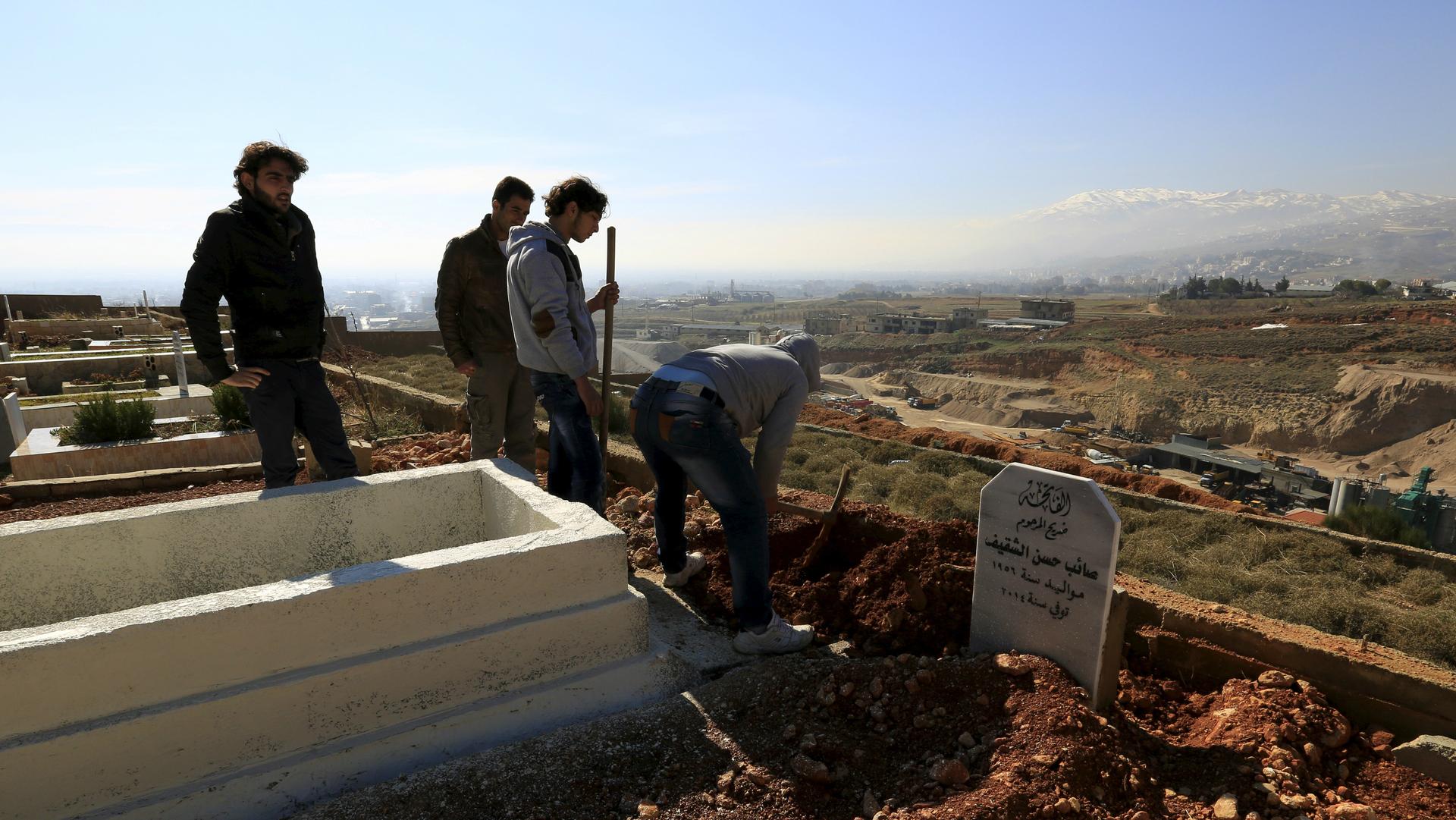 Men dig graves inside a graveyard for Syrian refugees in the village of Taalabaya, Bekaa Valley, Lebanon, Jan. 10, 2016.