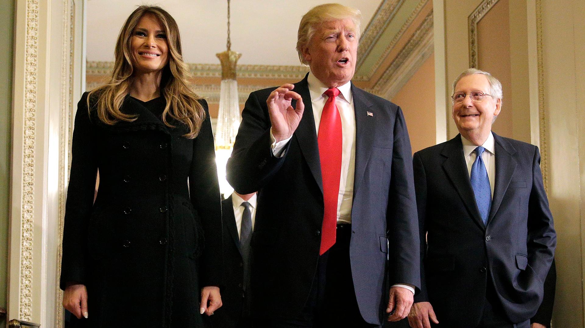 US President-elect Donald Trump (center) answers questions as his wife Melania Trump and Senate Majority Leader Mitch McConnell (R-Kentucky) watch on Capitol Hill in Washington DC on Nov. 10, 2016.