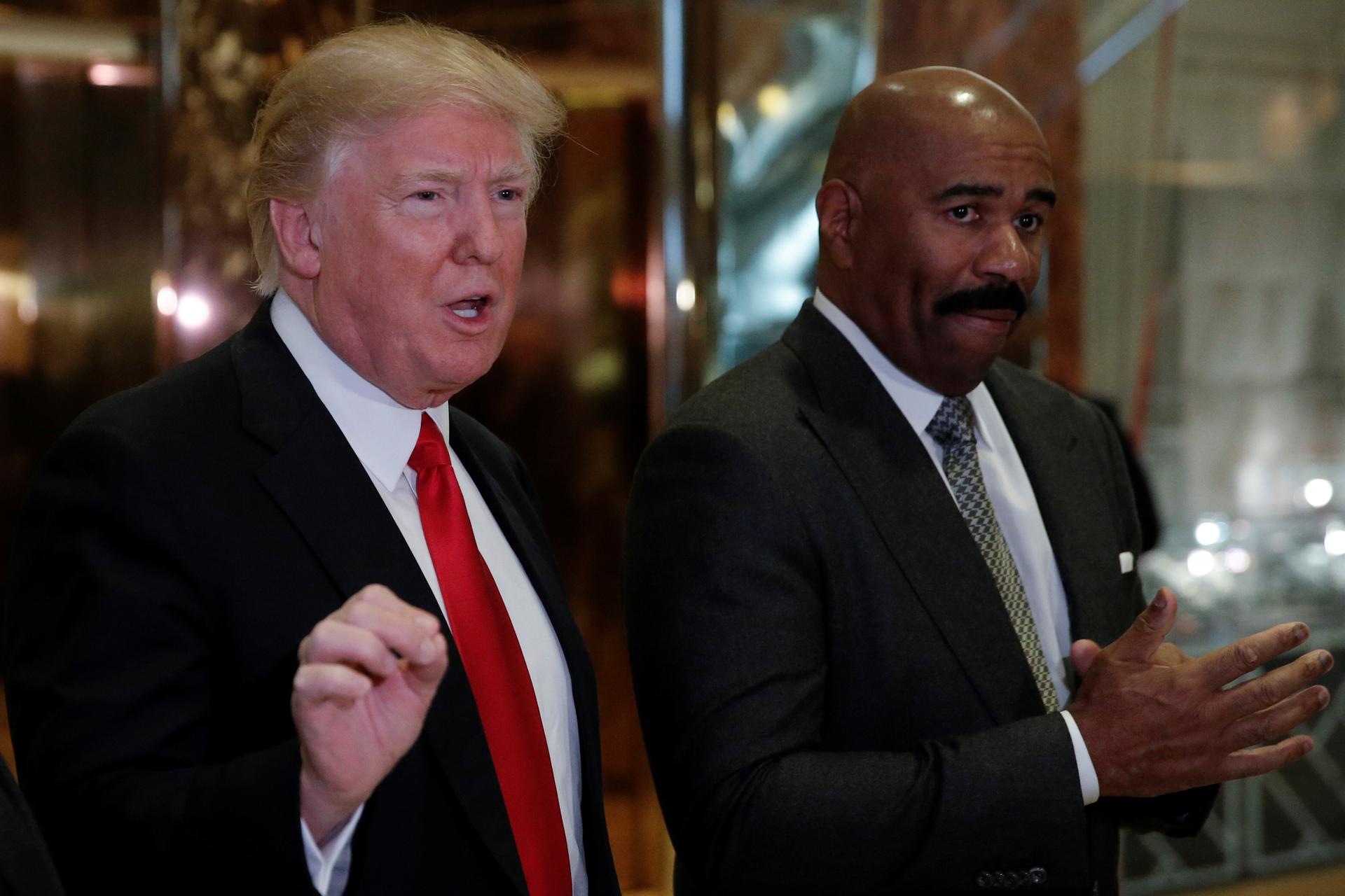 U.S. President-elect Donald Trump speaks to members of the news media with television personality Steve Harvey (R) after their meeting at Trump Tower in New York, U.S., January 13, 2017.