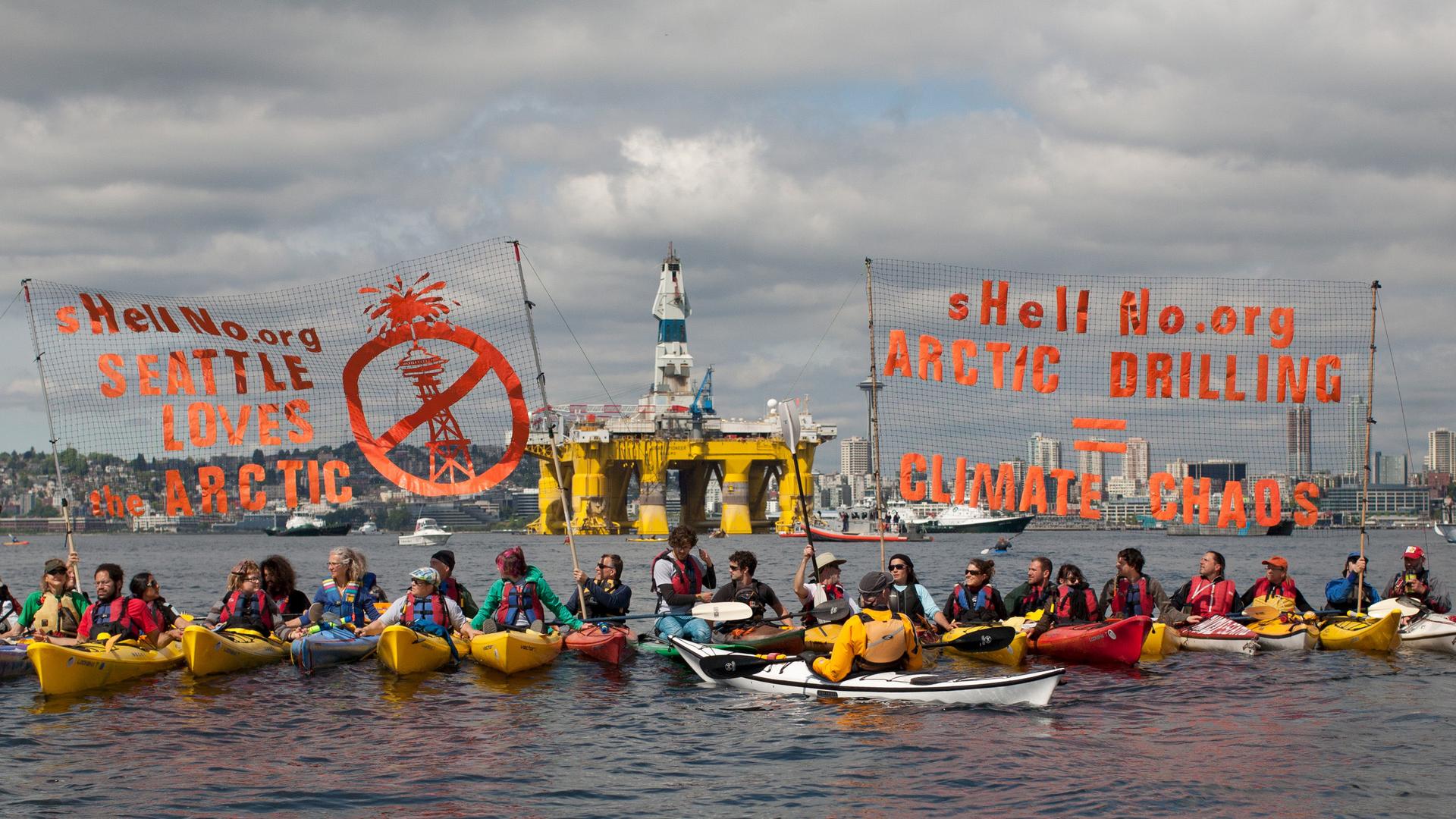 "Kayaktivists" demonstrate in Seattle's Elliot Bay against the arrival last month of the Shell's massive Polar Pioneer oil rig, rising behind them above the city's waterfront. Shell is using Seattle as a staging area for its new offshore drilling operatio