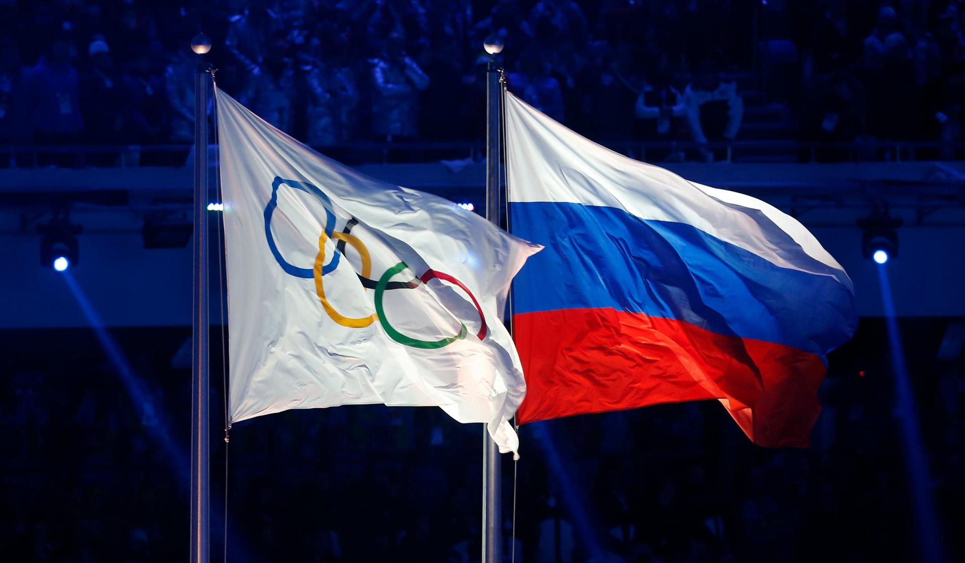 The Olympic and Russian flags are raised during the opening ceremony of the 2014 Sochi Winter Olympics.