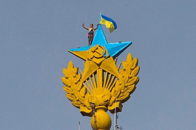 Atop the spire of a building in Moscow, a man takes a "selfie" as he stands with a Ukrainian flag on a Soviet-style star re-touched with blue paint to resemble the yellow-and-blue national colors of Ukraine.