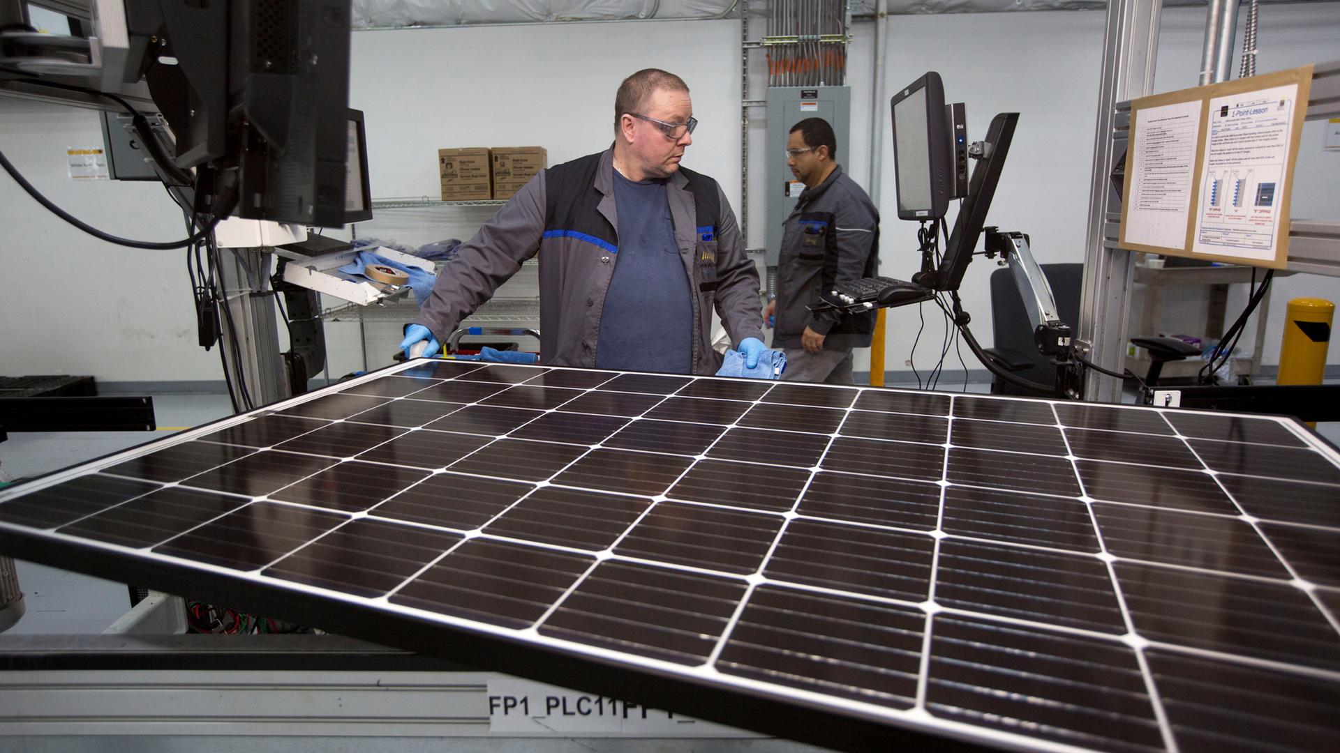 Production operator John White checks a panel at the SolarWorld solar panel factory in Hillsboro, Oregon.