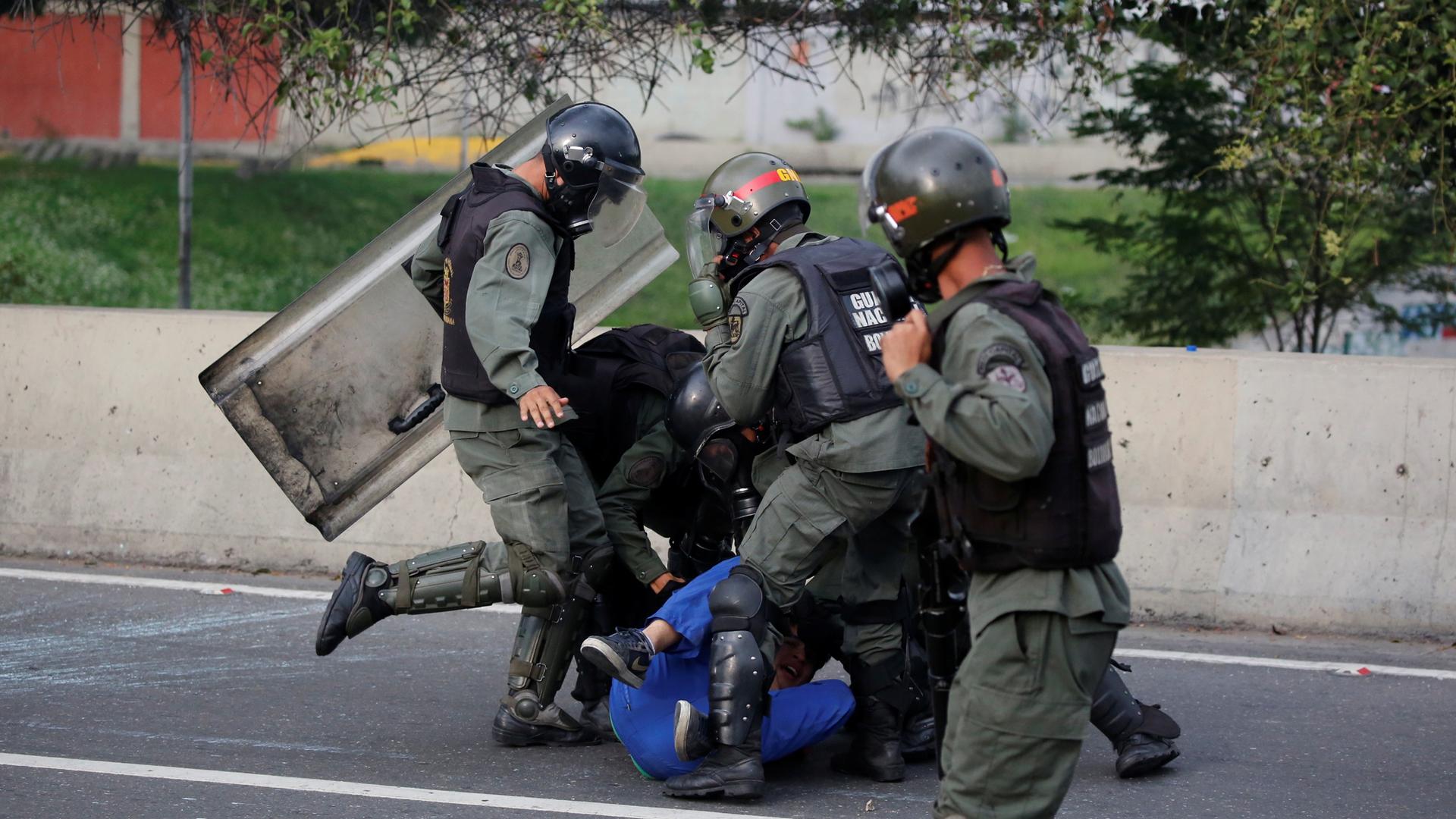 An opposition supporter is detained by riot police during a rally against President Nicolas Maduro in Caracas, Venezuela.
