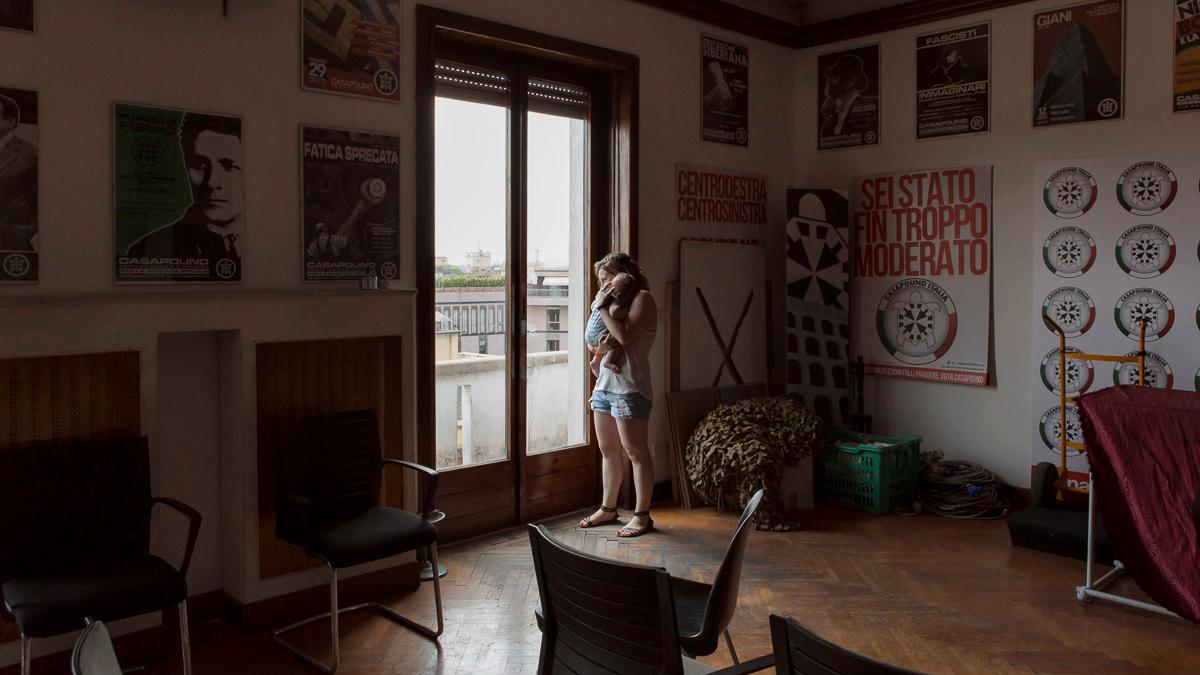 Estella and her four-month-old inside their squat house, which is also the headquarters of CasaPound, Italy's largest neo-Fascist movement. The walls are covered in ultra-nationalist posters.