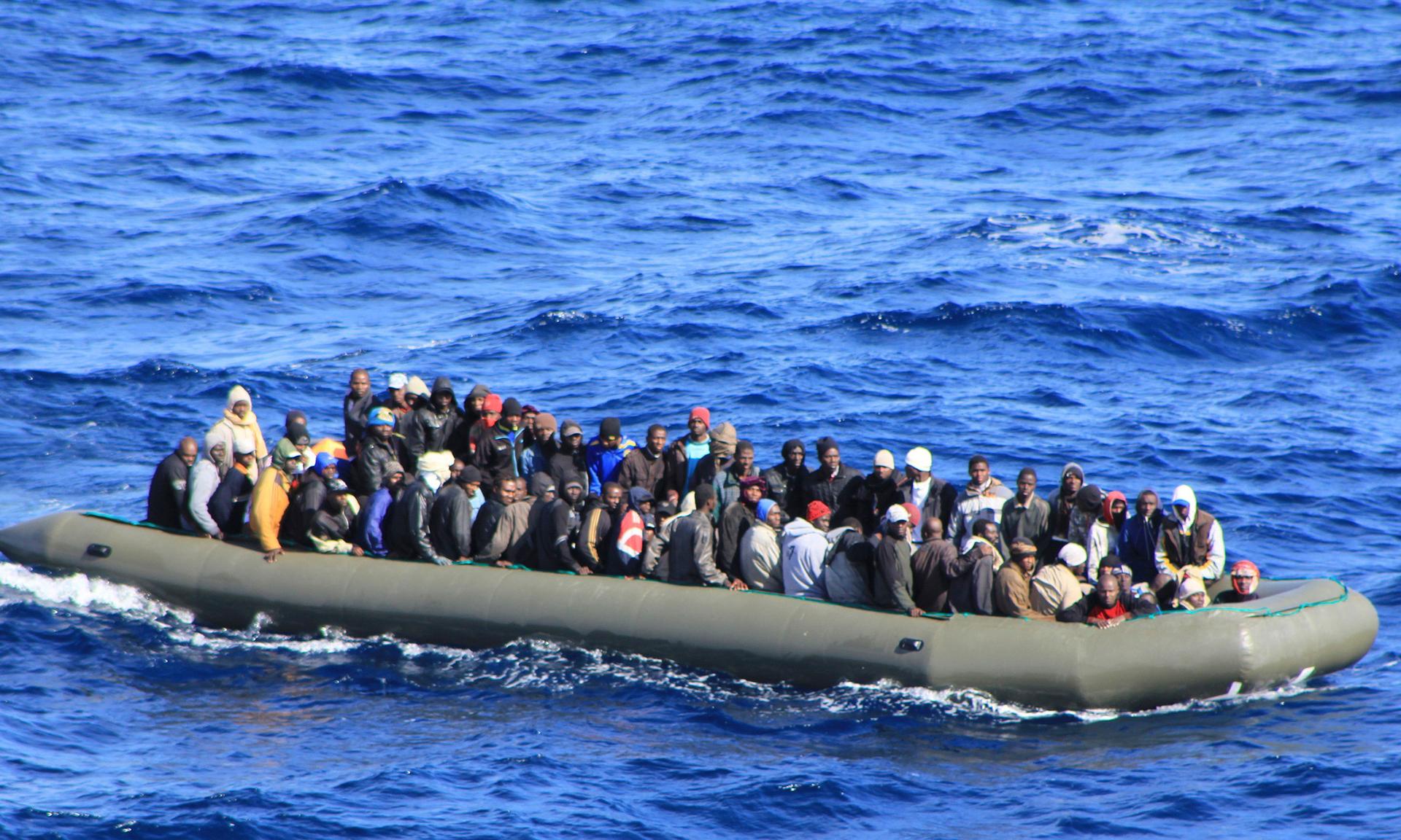 Migrants in a boat during a rescue operation by Italian navy ship San Marco off the coast to the south of the Italian island of Sicily.