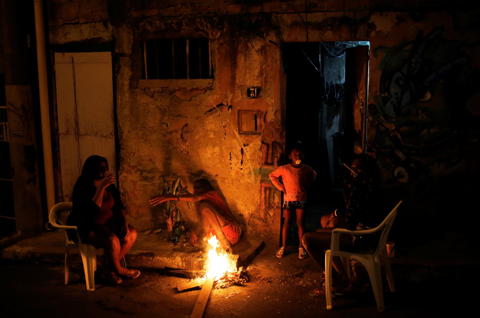 A family is pictured at the entrance of their house at a slum, or favela, in Rio de Janeiro