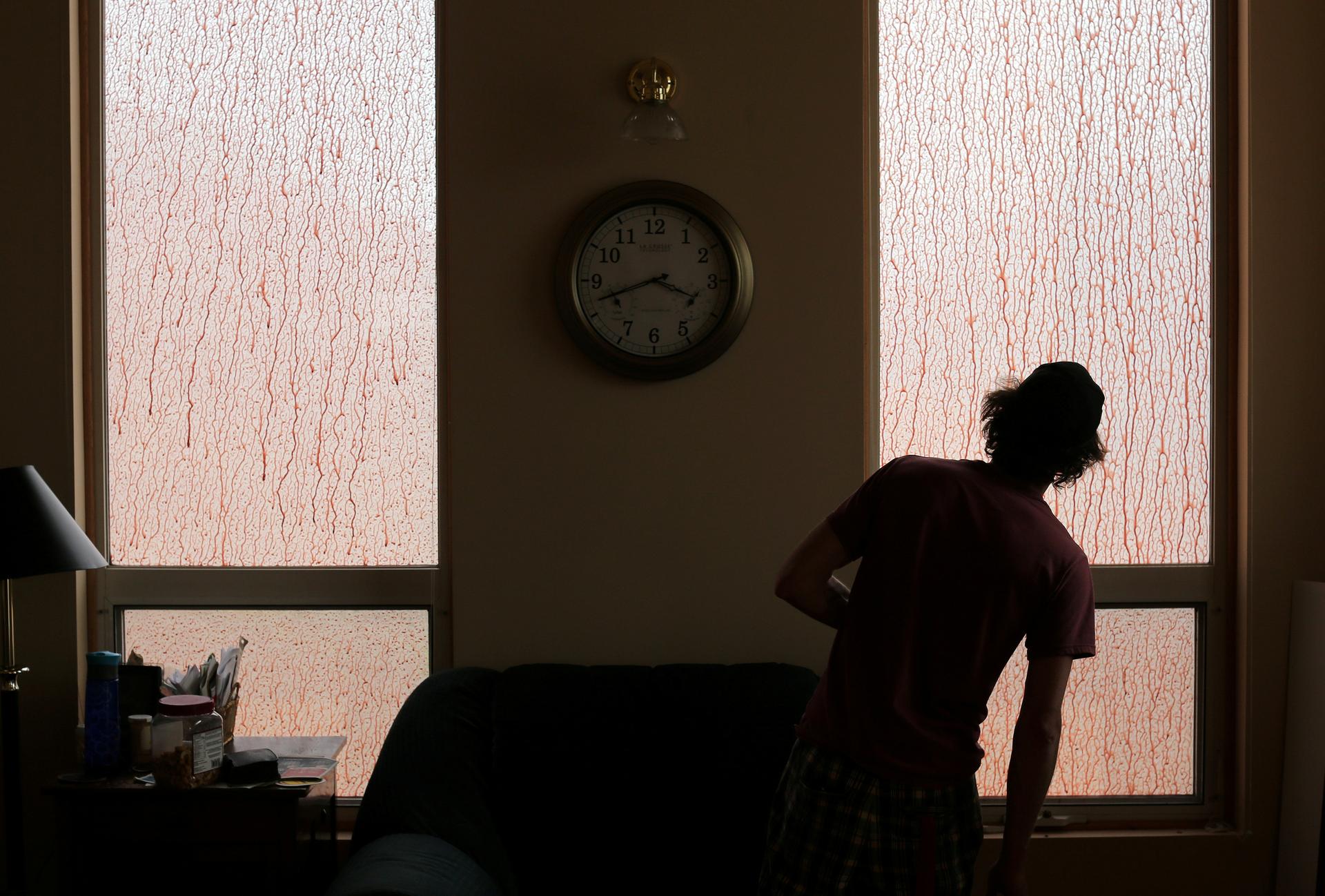 Wes Gerwien, 28, looks out a window of his family home