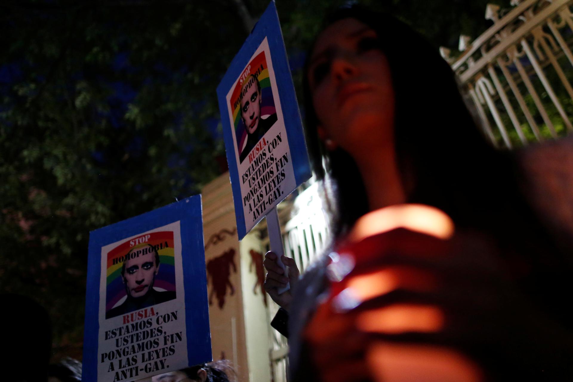 Members of the LGBT community hold a placard with the picture of Russia's President Vladimir Putin during a protest outside the Russian embassy in Mexico City.