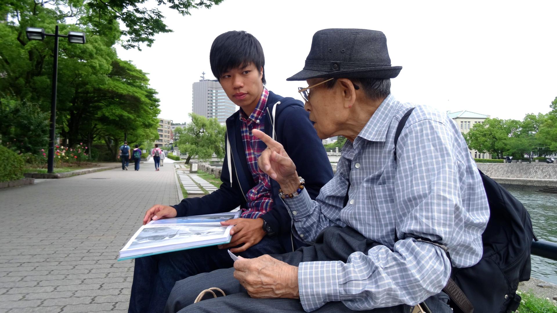 Masaaki Murakami, a volunteer guide at Hiroshima's Peace Memorial Park listens to 87-year-old atomic bomb survivor Noriho Azuma.