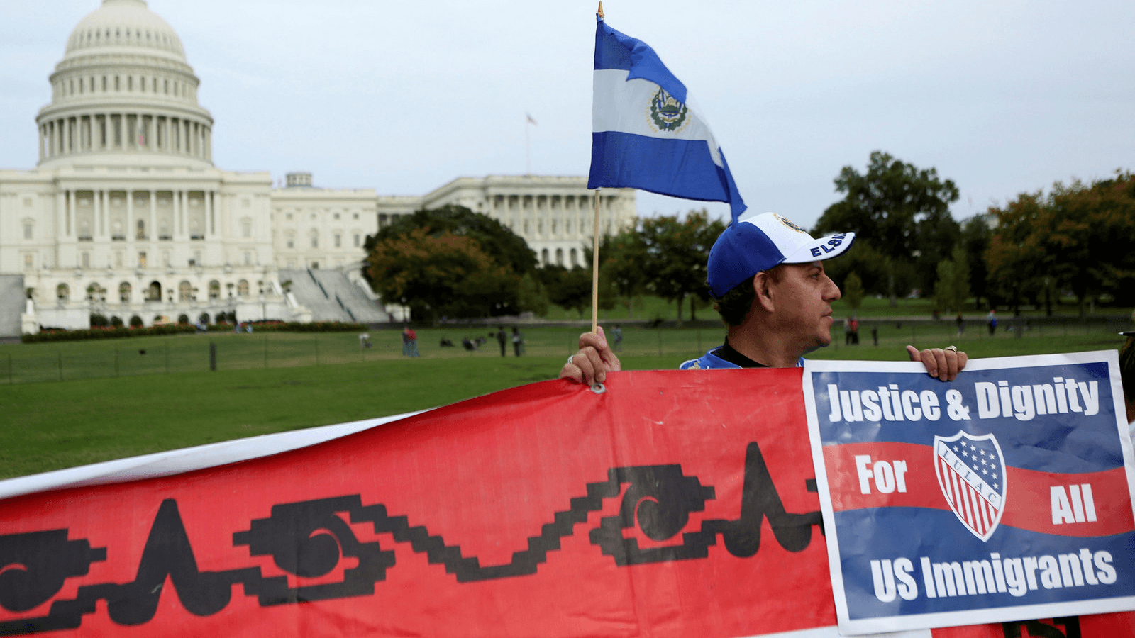 A Salvadoran man holds his nation's flag and a sign during a protest rally for immigrants rights on Capitol Hill in Washington, D.C., Oct. 8, 2013.
