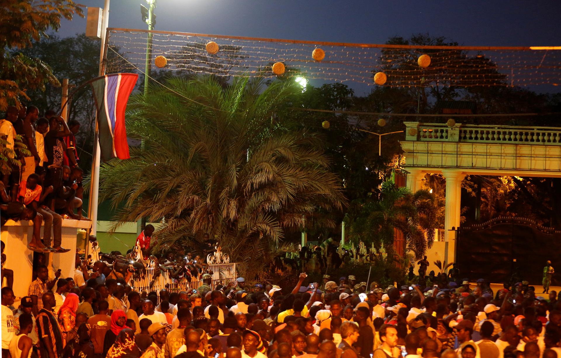 People are seen in front of Presidential Palace as they welcome members of the regional ECOWAS force