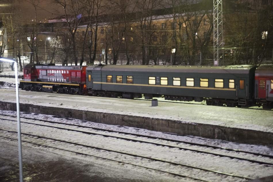 A passenger train starts, with a green carriage which is believed to transport 30 people who were arrested over a Greenpeace protest at the Prirazlomnaya oil rig seen in the train formation, in Murmansk on the way to St. Petersburg, November 11, 2013.