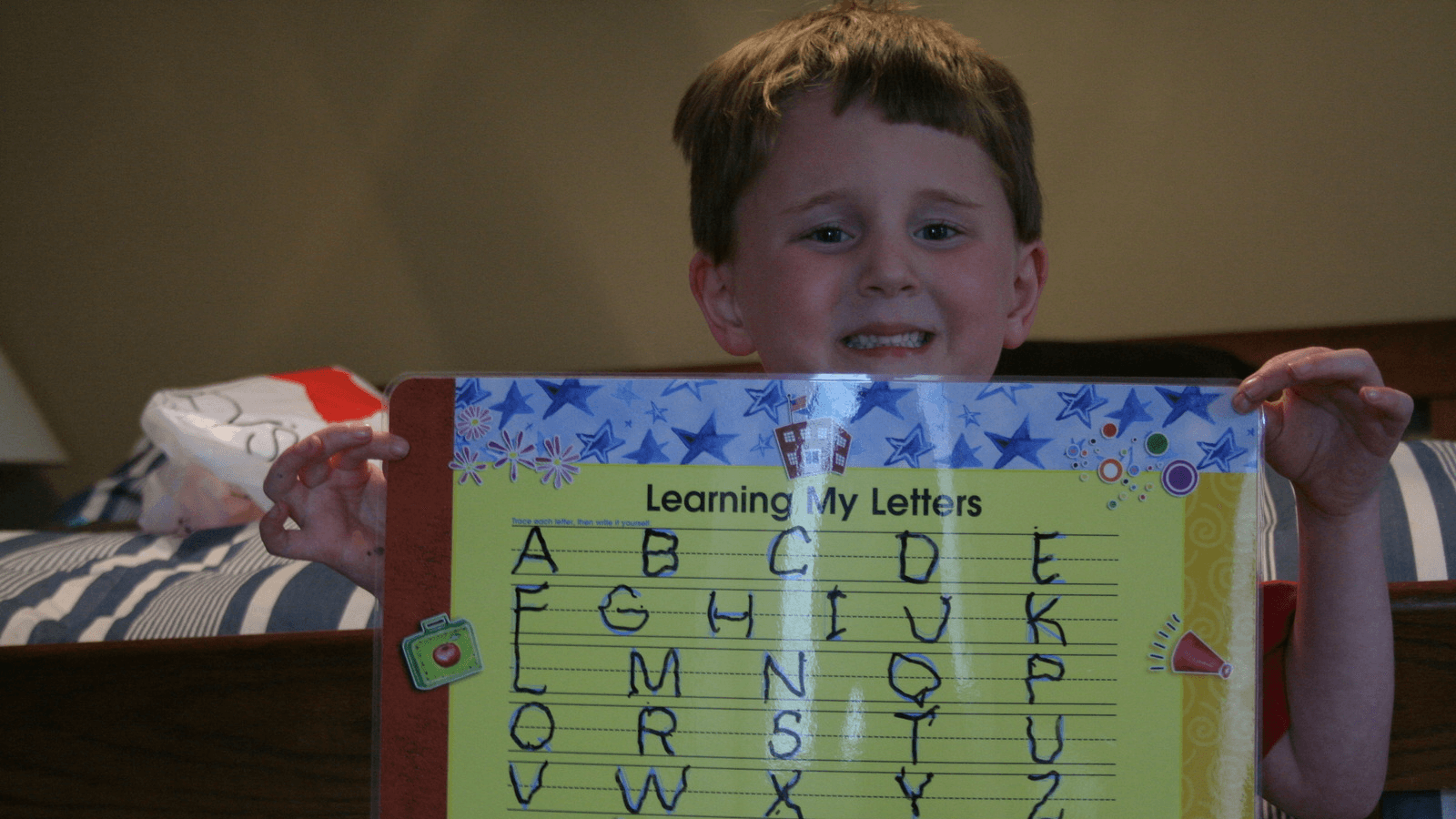 a boy shows off his handwriting practice