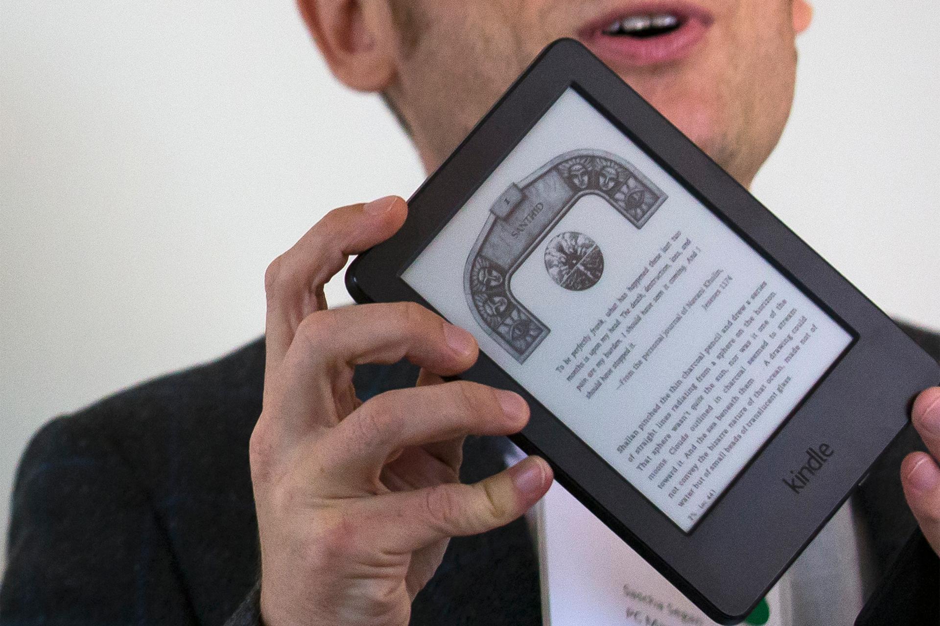 A journalist shows the new Kindle Voyage during a launch event in New York September 17, 2014.