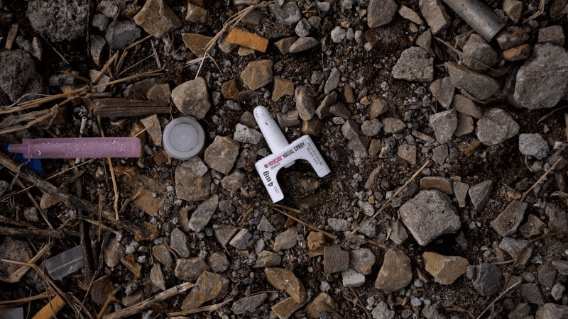 A used container of the drug Narcan, which is used against opioid overdoses, lies on the ground in a park in the Kensington section of Philadelphia, Pennsylvania, Oct. 26, 2017.