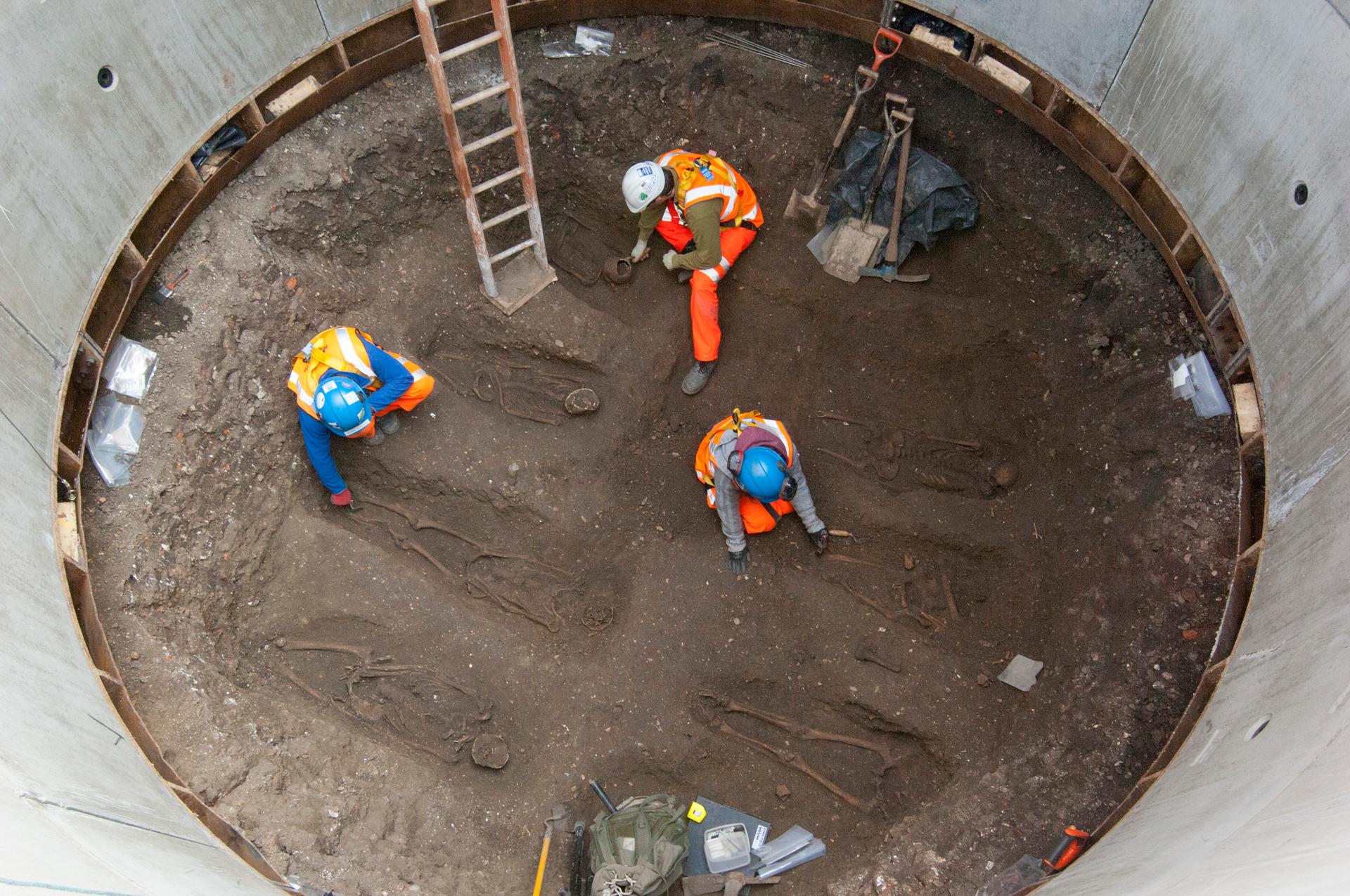 Archaeologists work on unearthed skeletons in the Farringdon area of London in this undated handout photograph released March 15, 2013. Archaeologists said on Friday they had found a graveyard during excavations for a rail project in London which might ho