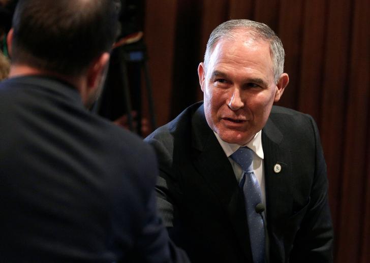 Scott Pruitt, the head of the Environmental Protection Agency, leans in as he shakes hands with an EPA employee.