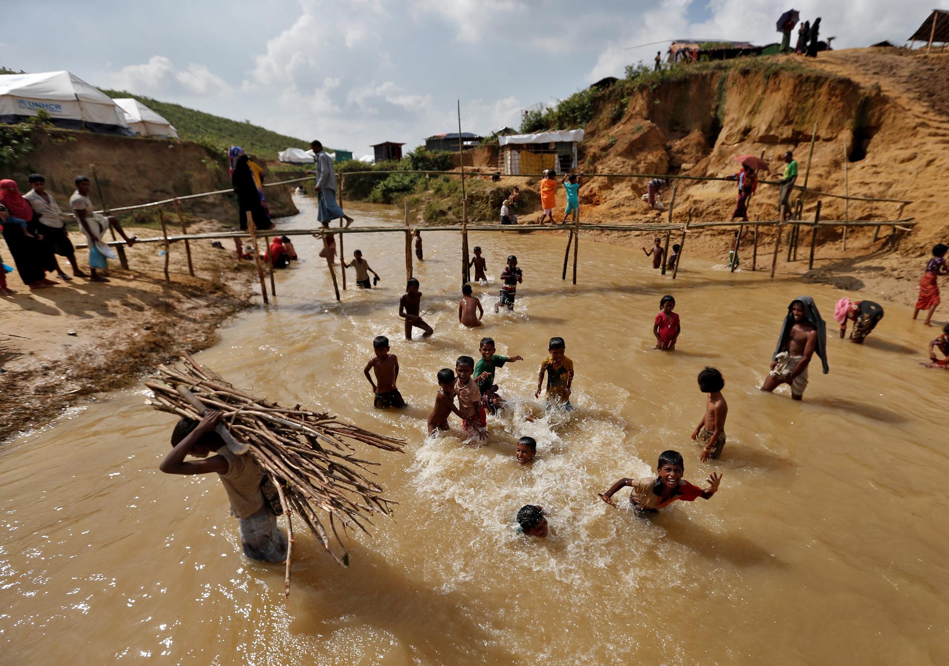 A Rohingya refugee carries firewood in a camp