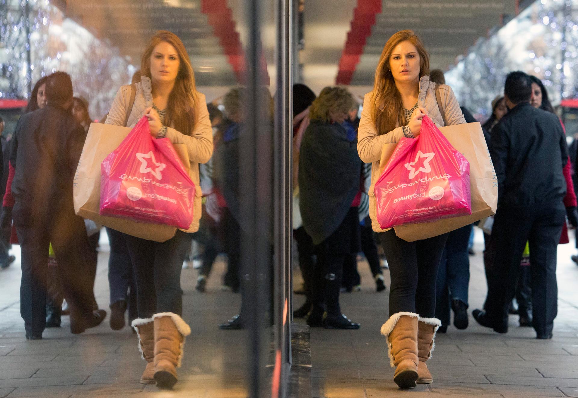 Pedestrians walk past a store on Oxford Street in central London December 15, 2013.