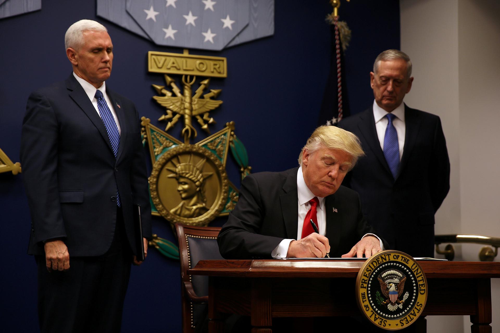 US President Donald Trump signs an executive order he said would impose tighter vetting to prevent foreign terrorists from entering the United States at the Pentagon in Washington, DC, January 27, 2017.