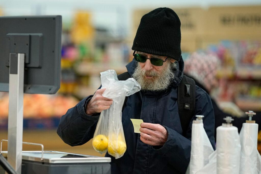 Мужчина покупает фрукты в гипермаркете в Москве.