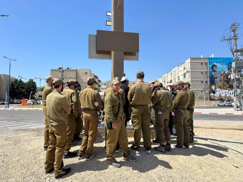 In the city of Sderot, Israeli soldiers gather around a memorial at the local police station where officers battled against Hamas fighters on Oct. 7, 2023.