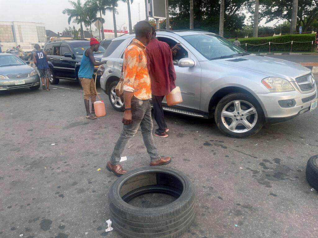 Black market sellers take advantage of fuel shortages to sell at exorbitant prices on busy roads in Lagos.