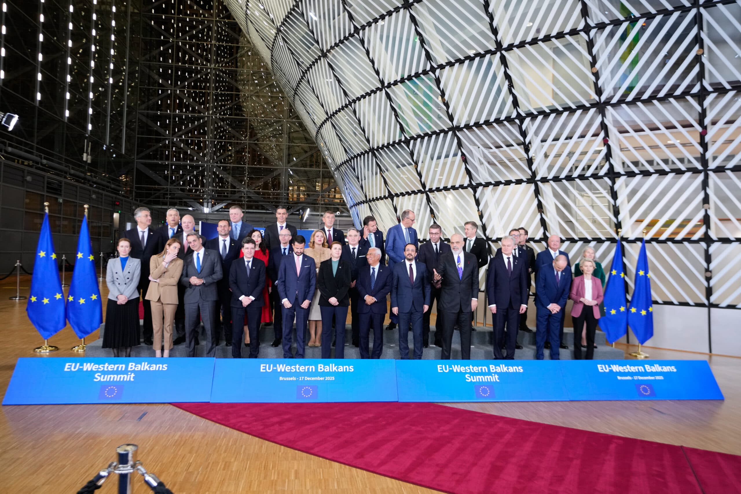Leaders and officials pose for a group photo at the EU-Western Balkans Summit in Brussels on December 17, 2025, with EU flags displayed on either side.