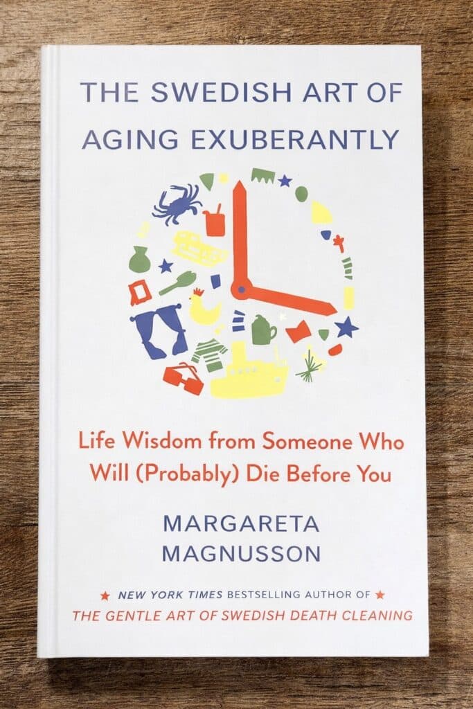 Cover of the book 'The Swedish Art of Aging Exuberantly' by Margareta Magnusson, featuring a colorful clock design made up of various icons, and text indicating it provides life wisdom from someone older.