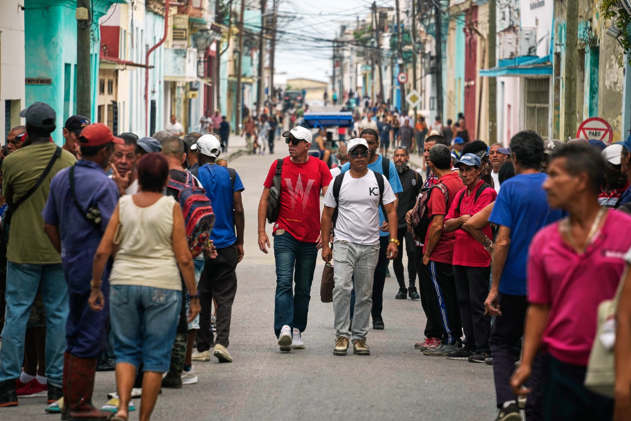 A busy street filled with people walking in both directions, with colorful buildings lining the sides.