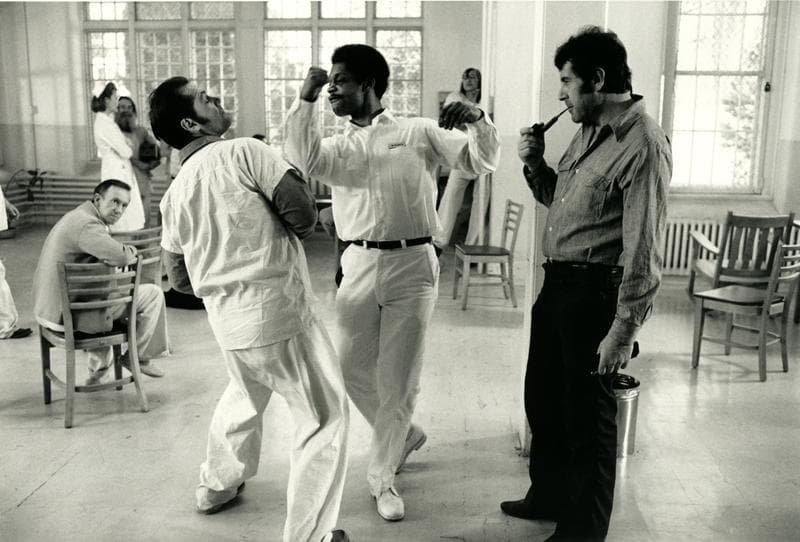 Jack Nicholson and another actor play a scene while director Milos Forman watches. 