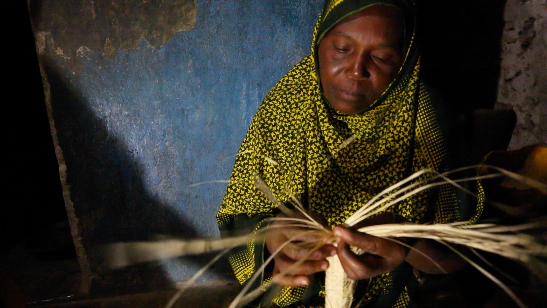 Kanoa Sharif Haji, a 45 year old mother of eight, weaves reed mats at night under a bright solar powered LED light at her home in Matemwe. This new work at night earns her family an extra fifteen dollars a month, a huge amount in these parts.