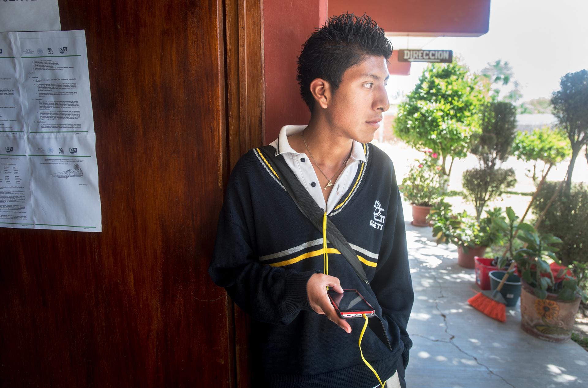 Student with headphones in outdoor school hallway
