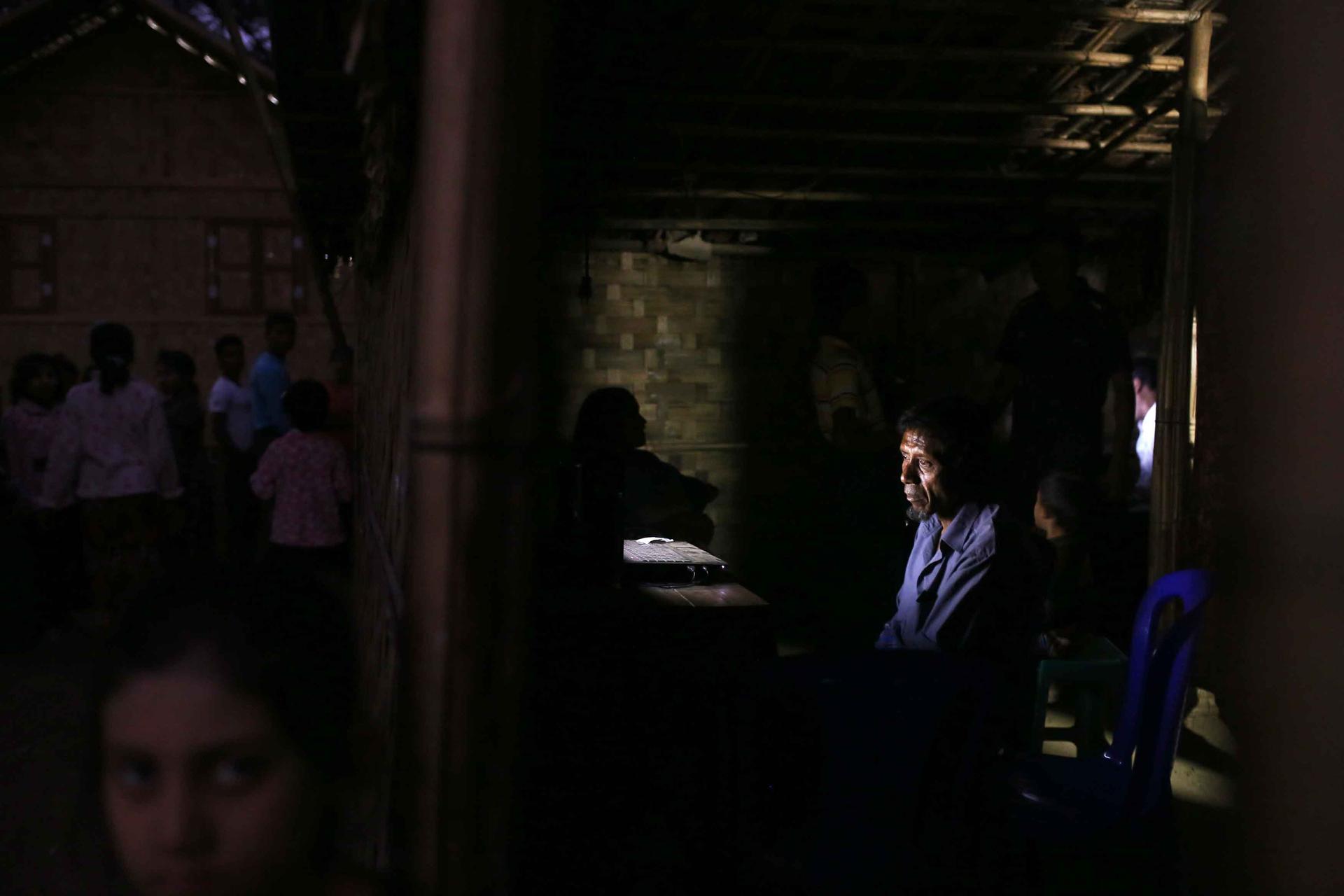People gather in and around an Internet hut in Thae Chaung village where operators of the huts charge customers 10 cents a minute to talk to relatives who have left Rakhine State by boat to seek work overseas.