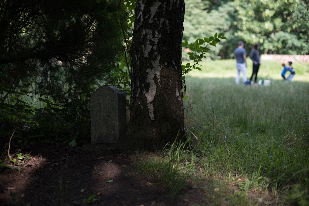 A young family plays in Berlin’s Leise Park, just yards way from this headstone. Though many of the headstones and remains have been removed from the park, some remain.