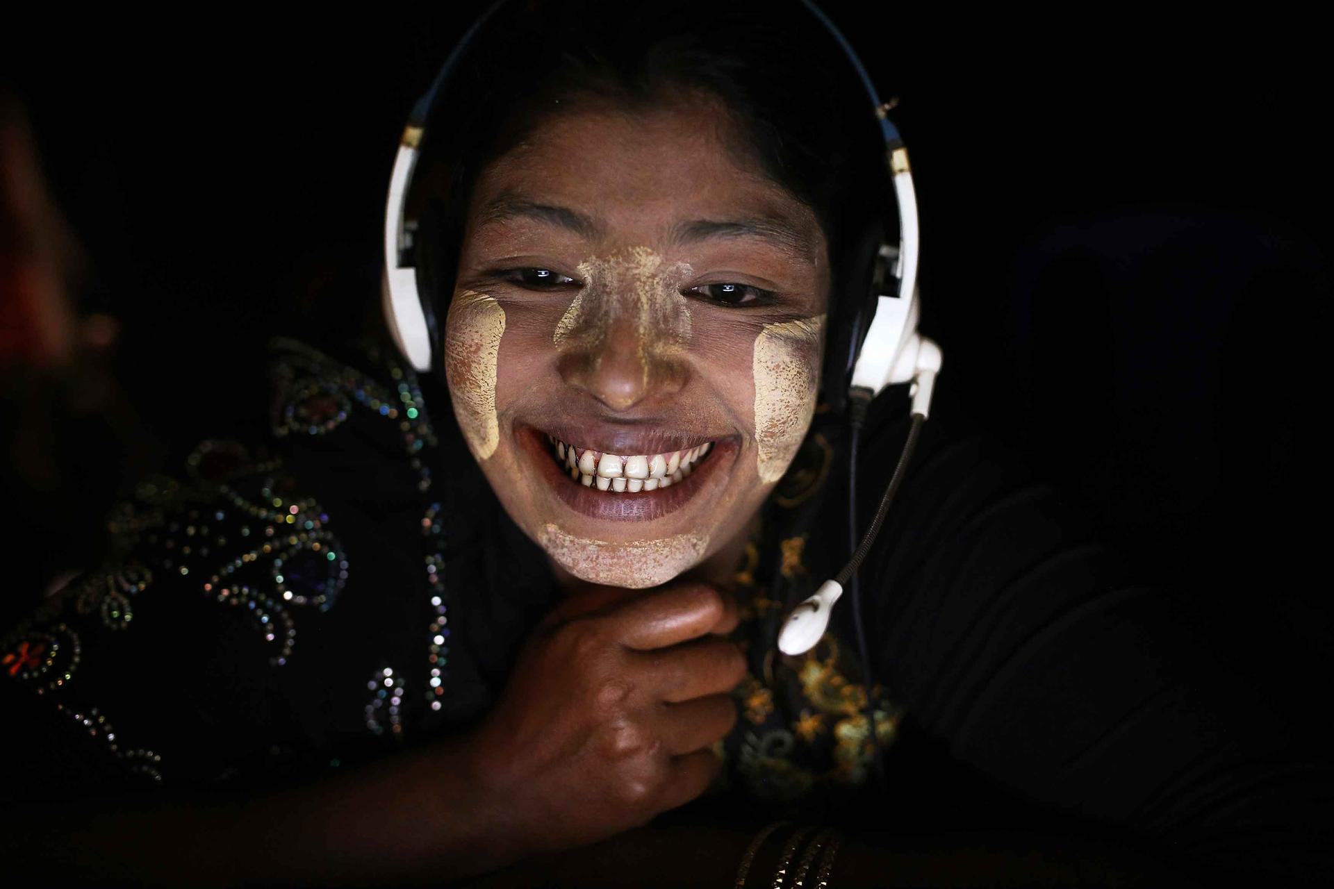 Sohidar, 25, a Rohingya mother of four, enjoys an Internet reunion with her husband Muhammad Shamin, 30, who works in Malaysia. Her face is smeared with a traditional Burmese cosmetic paste called thanaka. 