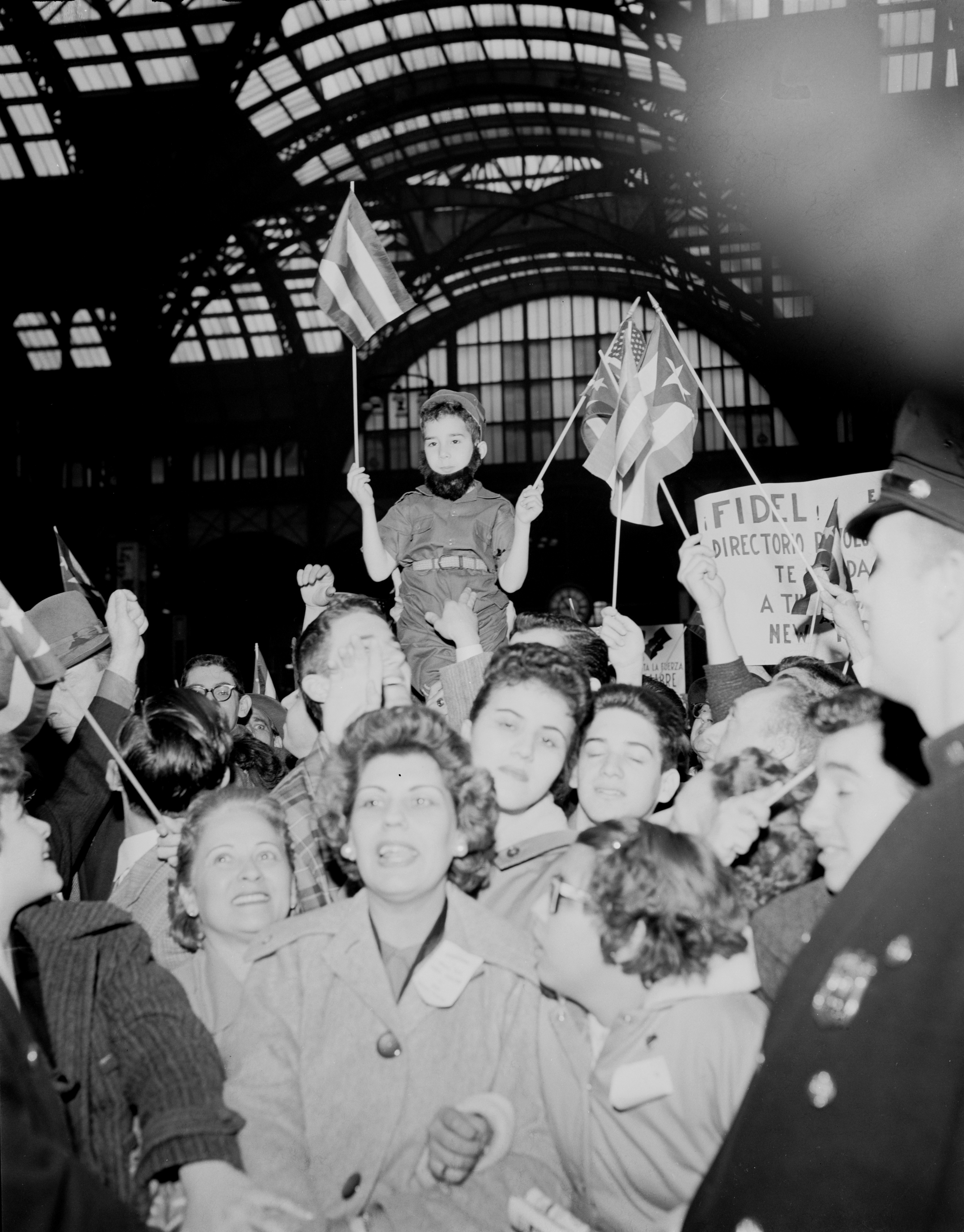April 21, 1959 - New York City, NY - This child, with a false beard in the style of Fidel Castro, is carried on the shoulders of sympathizers of the revolutionary leader, as they await his arrival at Penn Station.