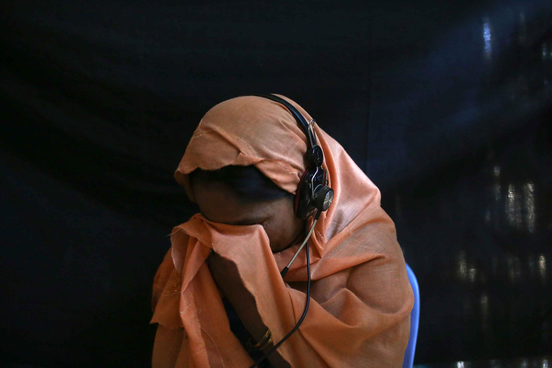 Rahana, a 32-year-old Rohingya, cries as she talks with traffickers from an Internet hut. She has already sent $1,100 to the trafficker who is holding her 12-year-old son ransom at a camp along the Thailand-Malaysia border. The trafficker wants another $3
