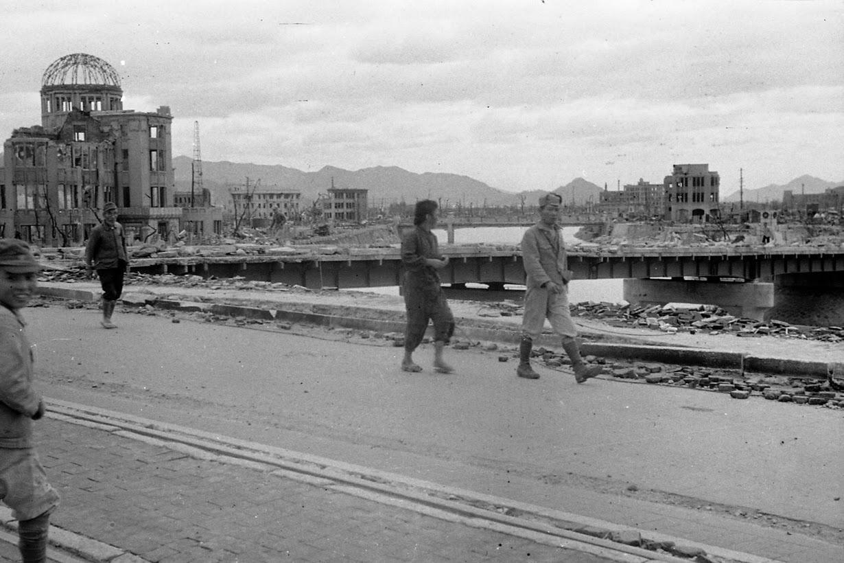 People walk over Aioi Bridge as the gutted Hiroshima Prefectural Industrial Promotion Hall, currently known as Atomic Bomb Dome or A-Bomb Dome, is seen in the background.