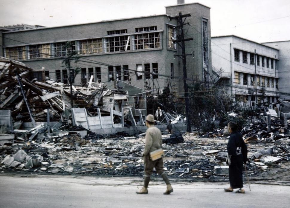 People walk past the Hiroshima Red Cross Hospital after the atomic bombing. November, 1945.