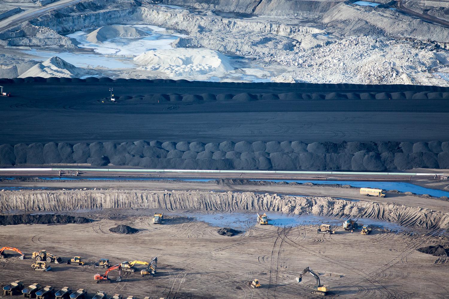 Piles of uncovered petroleum coke, a byproduct of upgrading tar sands oil to synthetic crude, sit at the Suncor Oil Sands Project. 