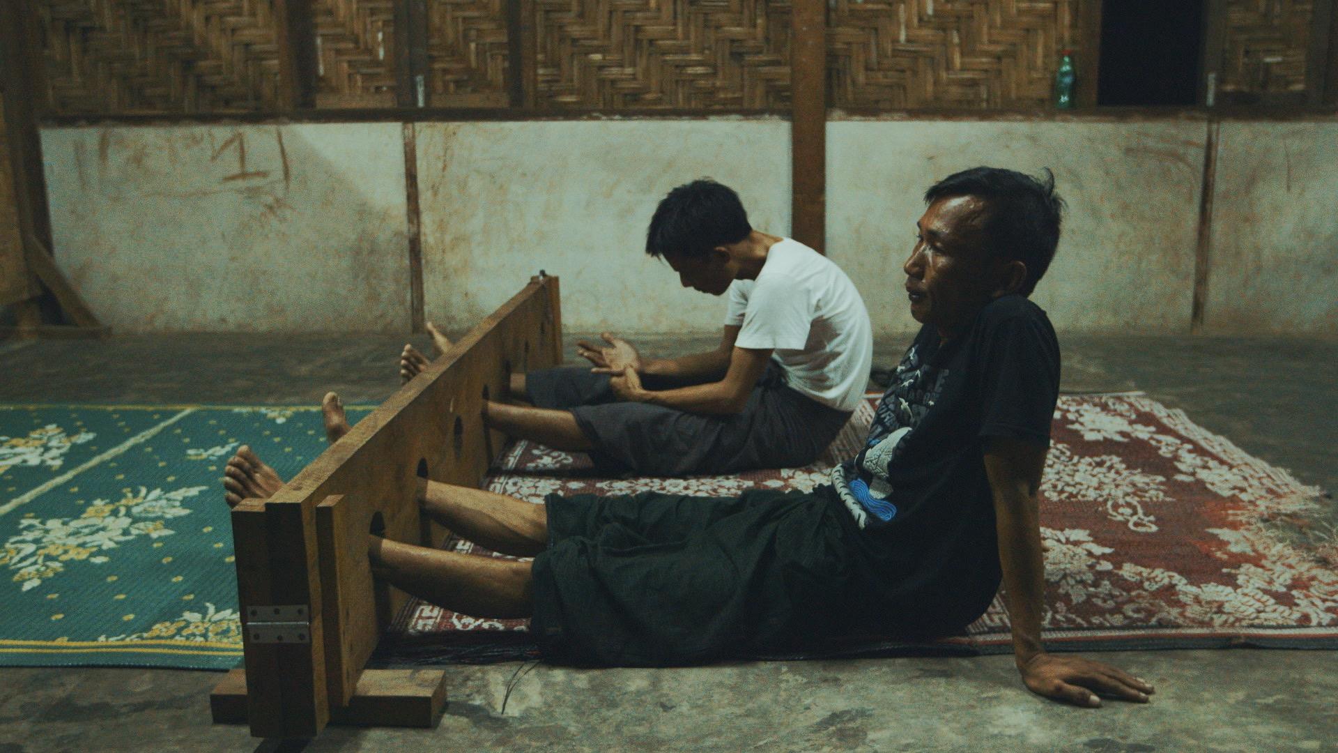 Accused drug users, captured in night raids by anti-drug vigilantes, are detained in wooden stocks inside a church in Myitkyina. Those detained by the anti-drug Patjasan are often flogged with bamboo rods and forced to denounce drugs.